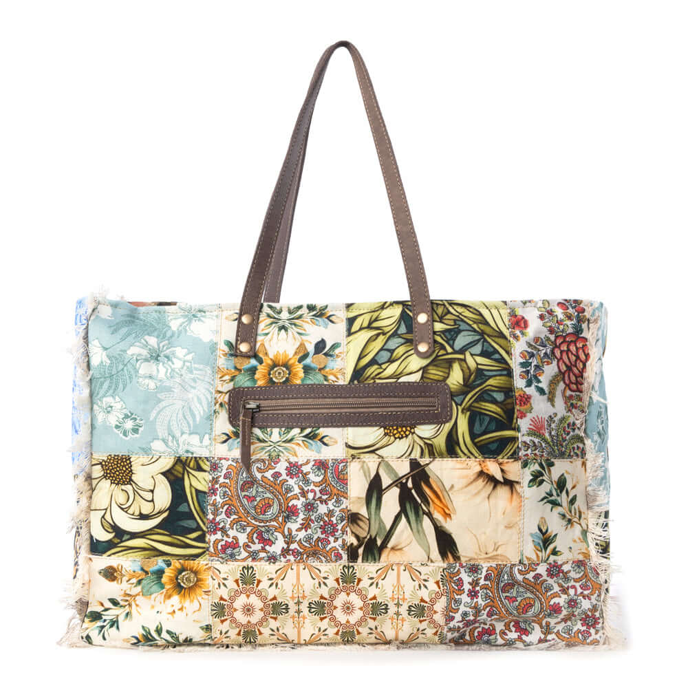 Myra Sundial Hollow Weekender Bag in Multi Patch with vibrant patchwork design and brown leather handles.