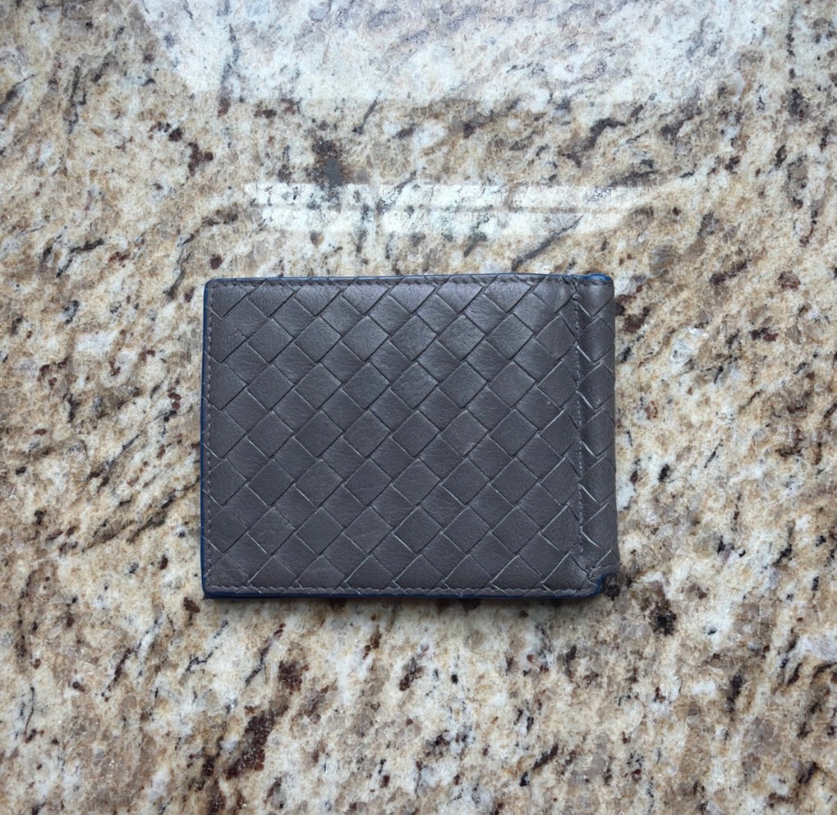 Gray woven Bottega Veneta money clip wallet exterior showing edge wear