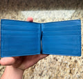 Blue interior with six card slots and central metal money clip