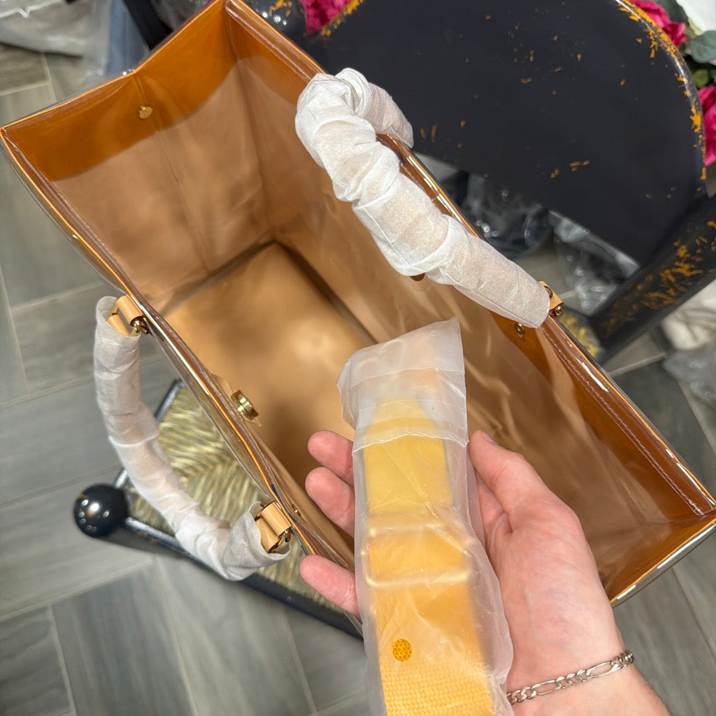 Actual independently upcycled orange shopping-bag tote with clear cover